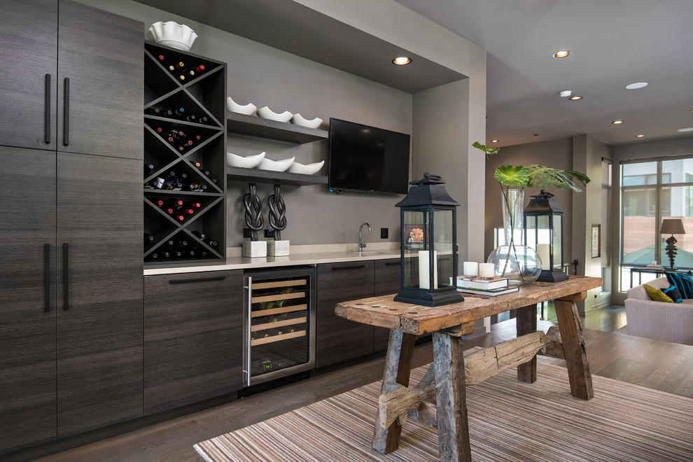 This is an example of a transitional single-wall wet bar in Chicago with flat-panel cabinets, dark wood cabinets and dark hardwood floors.