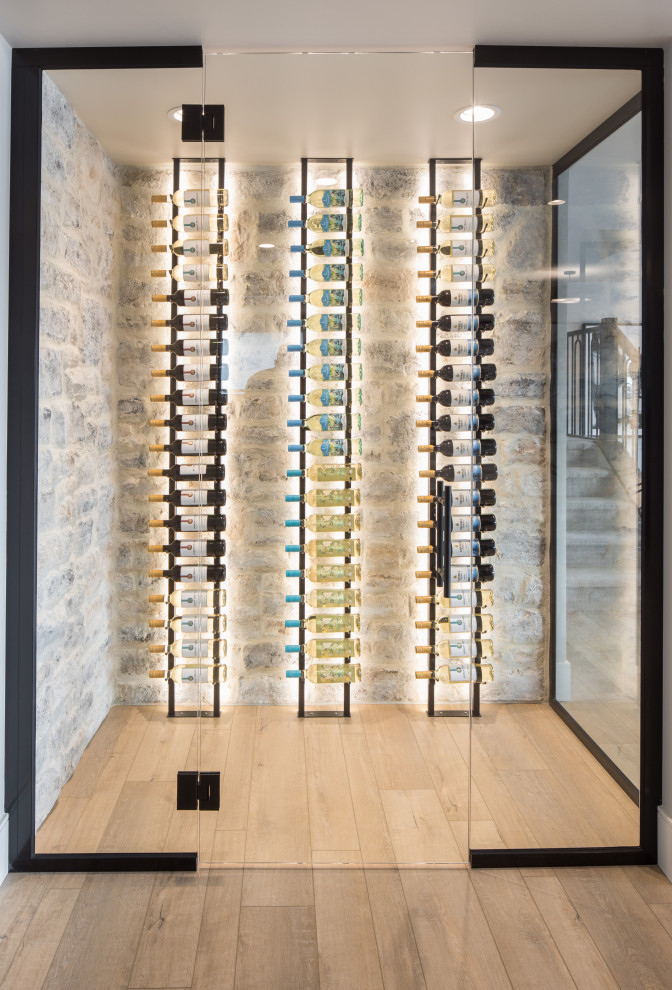 Inspiration for a mid-sized country wine cellar in Calgary with laminate floors, display racks and brown floor.