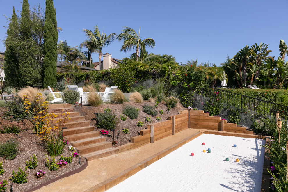 This is an example of a mid-sized modern backyard full sun xeriscape for summer in Orange County with decomposed granite and a metal fence.