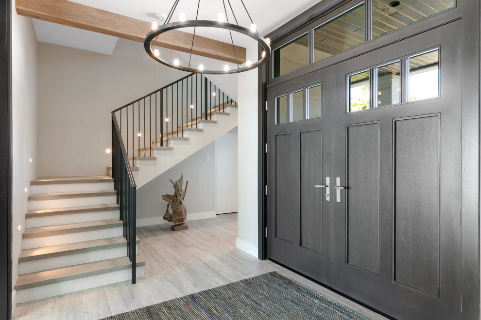 This is an example of a large beach style entry hall in Tampa with grey walls and grey floor.