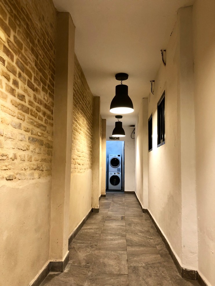 This is an example of a mid-sized transitional hallway in Seville with beige walls, porcelain floors and grey floor.