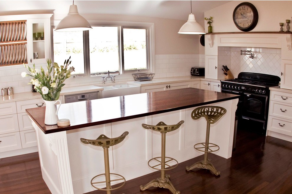 Design ideas for an eclectic kitchen in Sydney with white cabinets, wood benchtops, white splashback and with island.