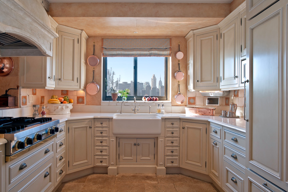 This is an example of a traditional u-shaped kitchen in New York with a farmhouse sink, raised-panel cabinets, beige cabinets, multi-coloured splashback and panelled appliances.