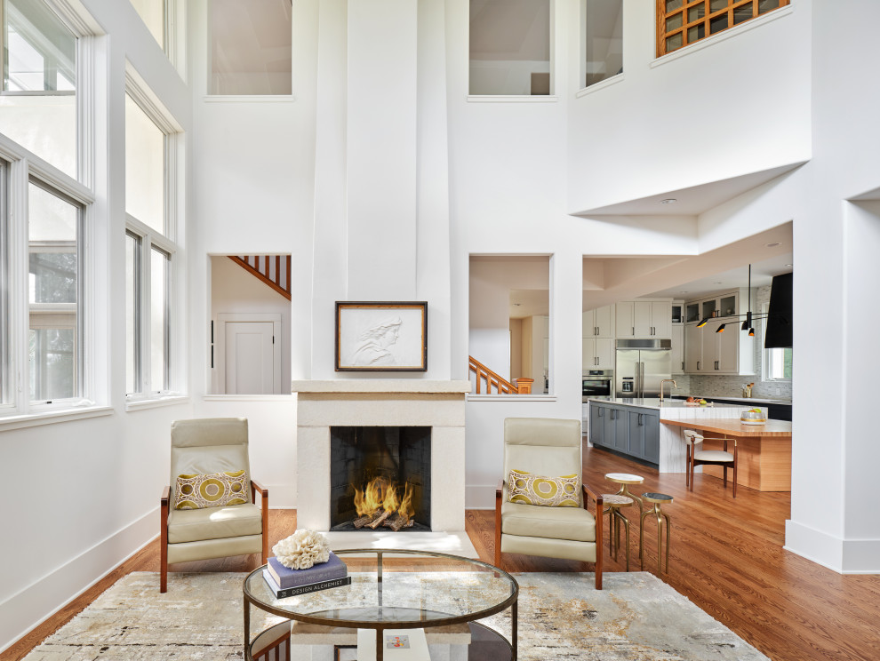 Foto di un soggiorno moderno aperto con sala formale, pareti bianche, pavimento in legno massello medio, cornice del camino in pietra e pavimento marrone
