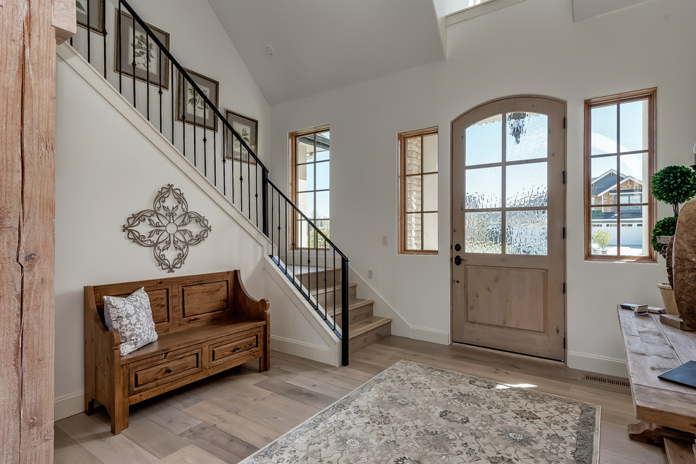 Design ideas for a traditional foyer in Boise with white walls, light hardwood floors, a single front door, a light wood front door and beige floor.