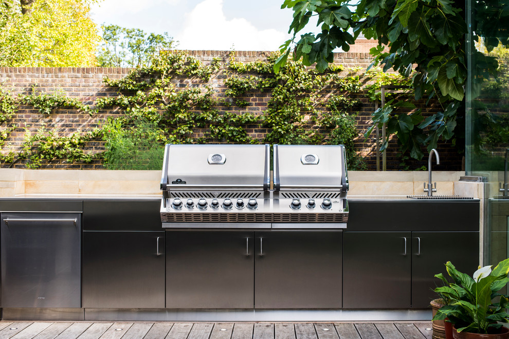 Inspiration for an eclectic back patio in London with an outdoor kitchen and no cover.
