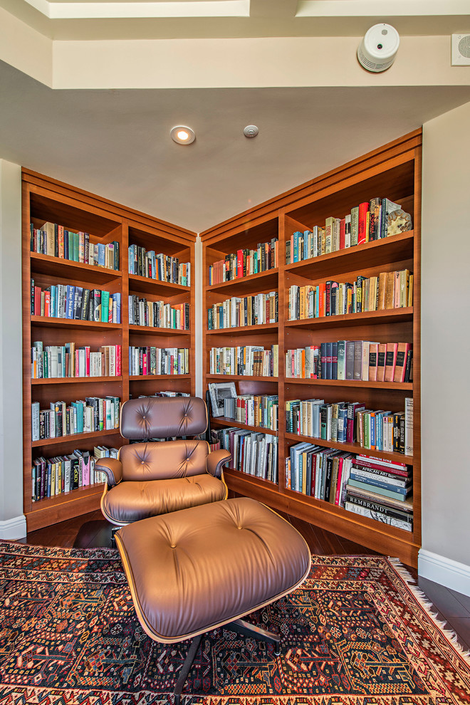 Photo of a small contemporary family room in Miami with a library, beige walls and dark hardwood floors.
