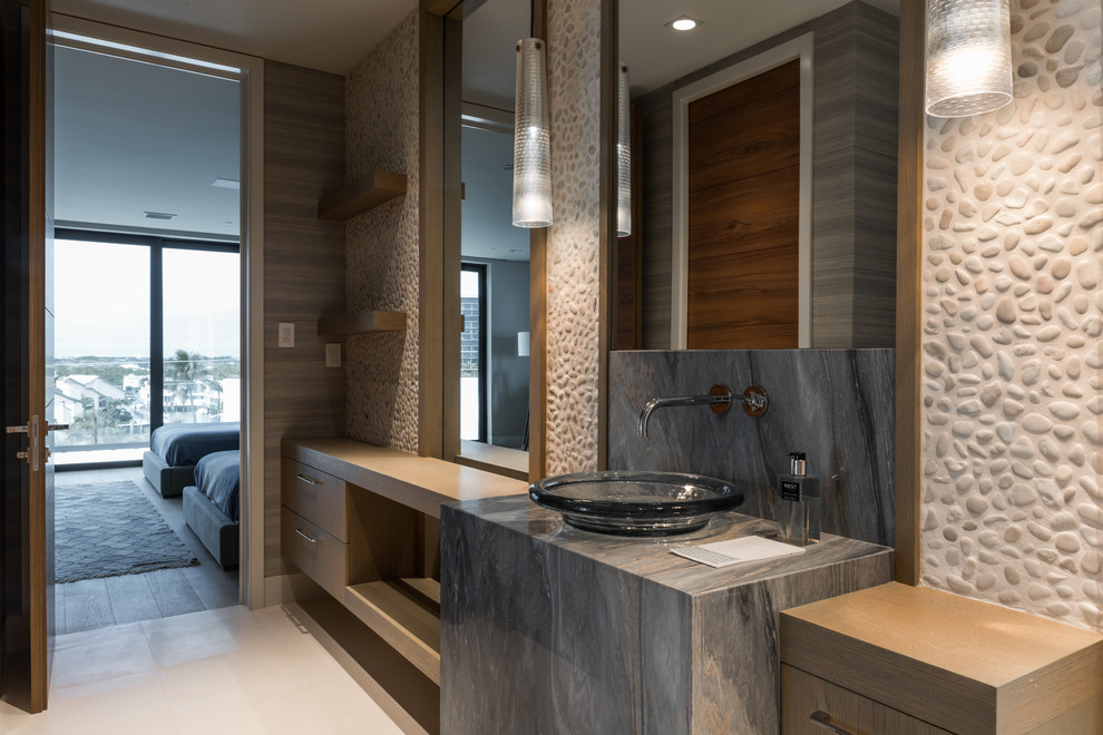 Photo of a mid-sized contemporary bathroom in Miami with flat-panel cabinets, medium wood cabinets, a curbless shower, with a sauna, a vessel sink, granite benchtops, beige tile, gray tile, pebble tile, multi-coloured walls, ceramic floors and beige floor.