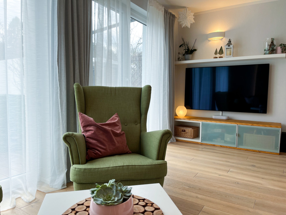 Modelo de salón abierto extra grande con paredes verdes, suelo de madera en tonos medios y panelado