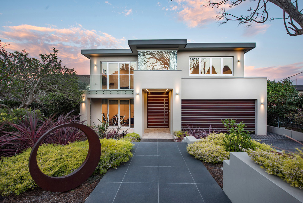 Inspiration for a contemporary two-storey beige house exterior in Sydney with a flat roof.