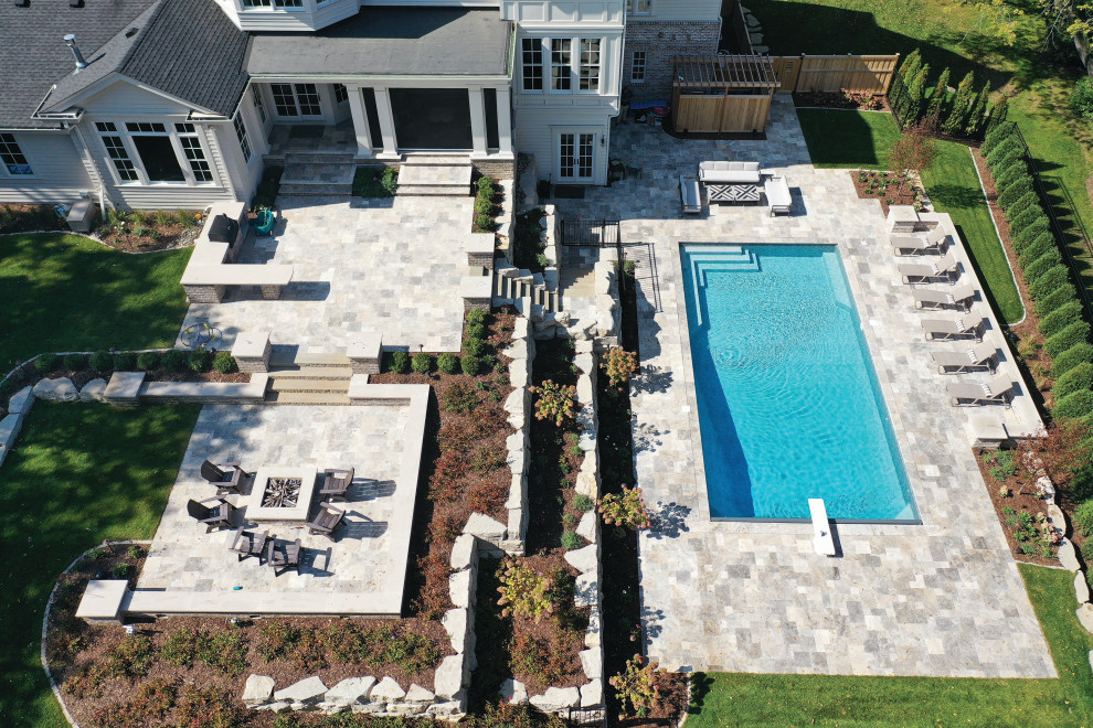 Ejemplo de piscina natural marinera grande a medida en patio trasero con paisajismo de piscina y adoquines de piedra natural