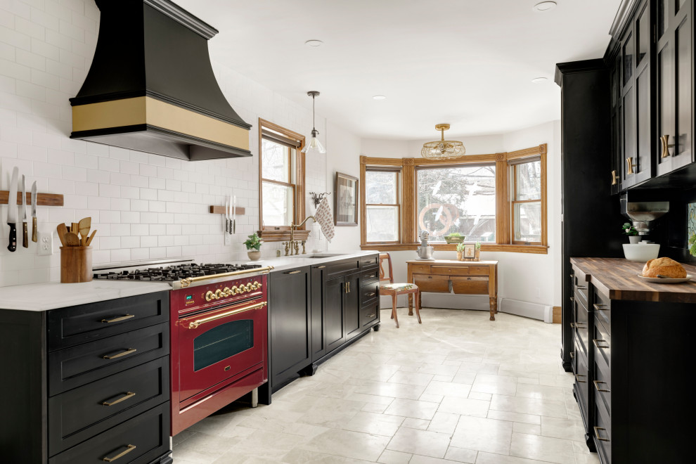 Photo of a large traditional galley eat-in kitchen in Minneapolis with an undermount sink, shaker cabinets, black cabinets, marble benchtops, white splashback, subway tile splashback, coloured appliances, marble floors, no island, beige floor and white benchtop.