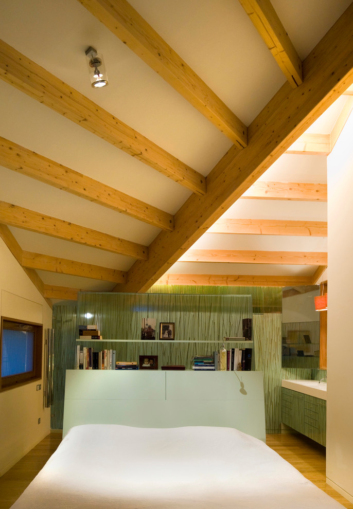 Foto di una camera matrimoniale design di medie dimensioni con pareti verdi, pavimento in legno massello medio e nessun camino