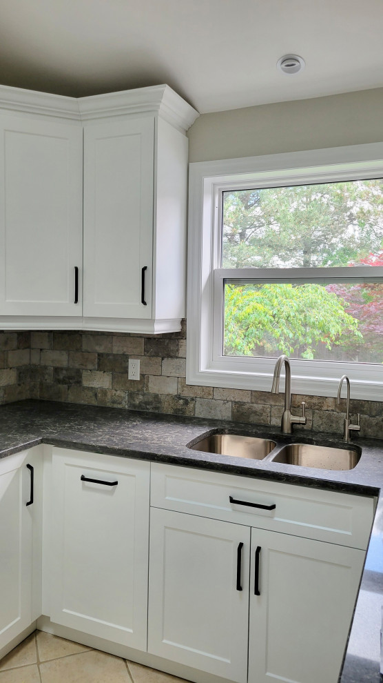 Transitional u-shaped open concept kitchen photo with an undermount sink, recessed-panel cabinets, white cabinets, multicolored backsplash, stone tile backsplash, stainless steel appliances and a peninsula