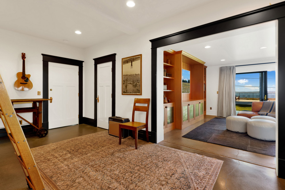 Mittelgroßer, Offener Uriger Hobbyraum ohne Kamin mit weißer Wandfarbe, Betonboden, TV-Wand und braunem Boden in Seattle