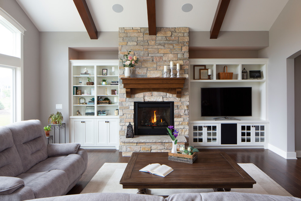 Large arts and crafts open concept family room in Milwaukee with grey walls, dark hardwood floors, a standard fireplace, a stone fireplace surround, a built-in media wall and brown floor.