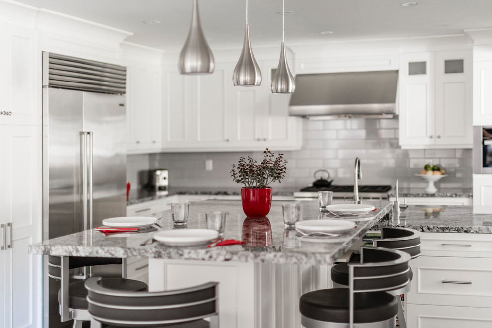 Kitchen - mid-sized transitional brown floor kitchen idea in Toronto with white cabinets, stainless steel appliances and an island