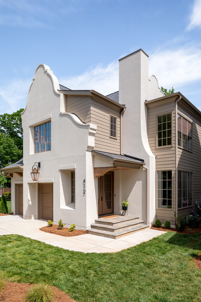 Photo of a traditional two-storey stucco white house exterior in Charlotte with a shingle roof and board and batten siding.