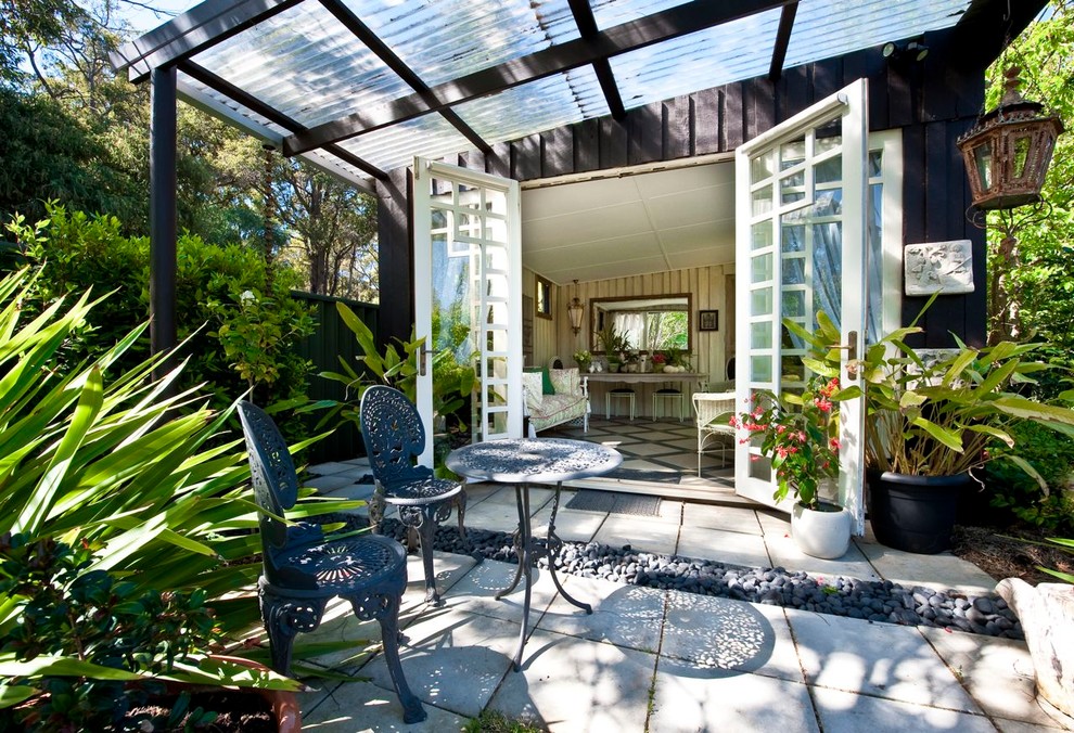 Photo of a mid-sized eclectic backyard patio in Perth with stamped concrete and a pergola.