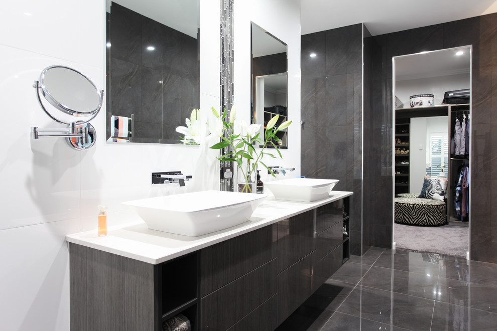 This is an example of a mid-sized contemporary master bathroom in Other with dark wood cabinets, an open shower, a wall-mount toilet, gray tile, cement tile, engineered quartz benchtops, flat-panel cabinets, ceramic floors, grey floor, white benchtops, a double vanity and a floating vanity.