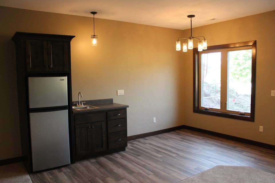 Inspiration for a mid-sized transitional u-shaped light wood floor eat-in kitchen remodel with a double-bowl sink, raised-panel cabinets, dark wood cabinets, granite countertops, multicolored backsplash, matchstick tile backsplash, stainless steel appliances and an island