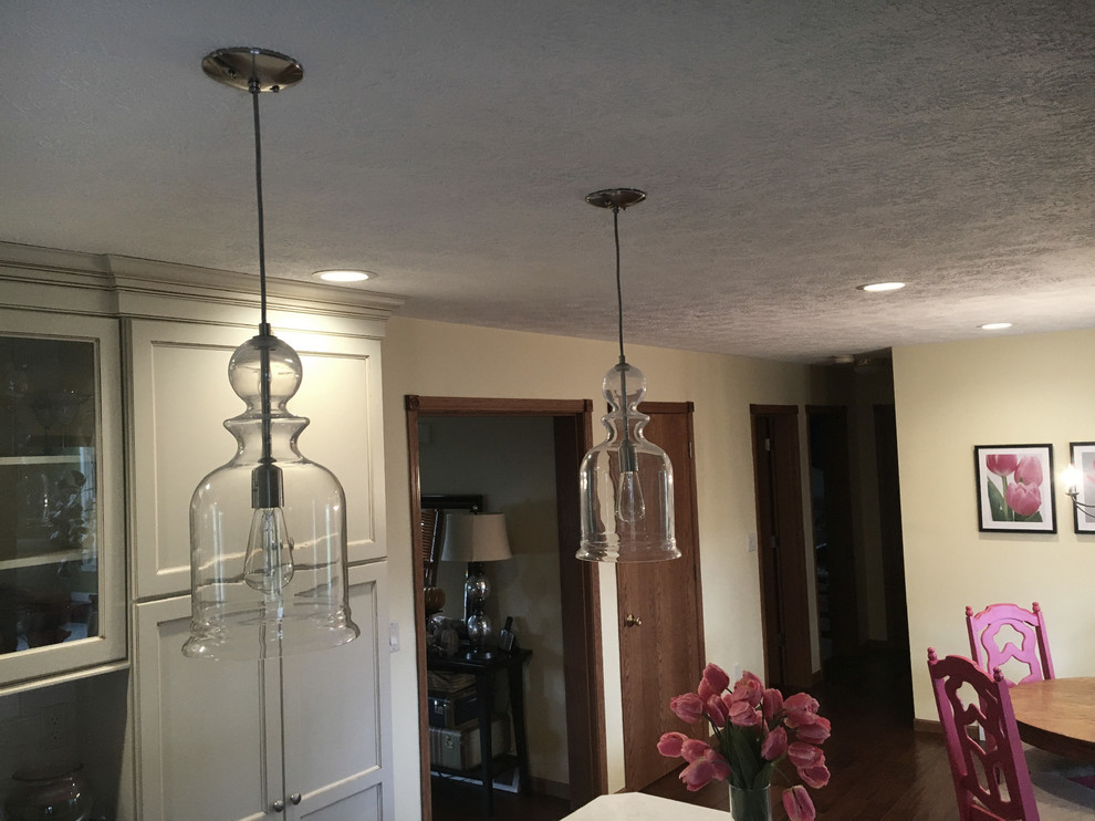 Inspiration for a large transitional medium tone wood floor and brown floor eat-in kitchen remodel with an undermount sink, flat-panel cabinets, white cabinets, granite countertops, white backsplash, porcelain backsplash, stainless steel appliances and an island