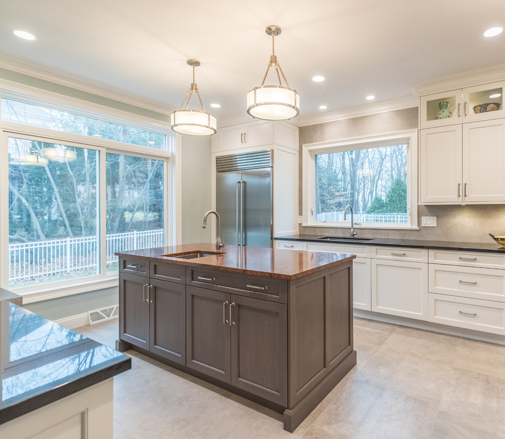 Example of a large transitional galley ceramic tile and gray floor open concept kitchen design in Bridgeport with an undermount sink, recessed-panel cabinets, white cabinets, granite countertops, gray backsplash, ceramic backsplash, stainless steel appliances, two islands and black countertops