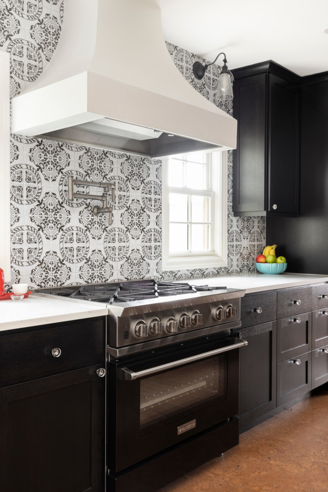 Foto på ett stort vit kök, med en rustik diskho, skåp i shakerstil, svarta skåp, bänkskiva i kvarts, flerfärgad stänkskydd, stänkskydd i terrakottakakel, svarta vitvaror, korkgolv och brunt golv