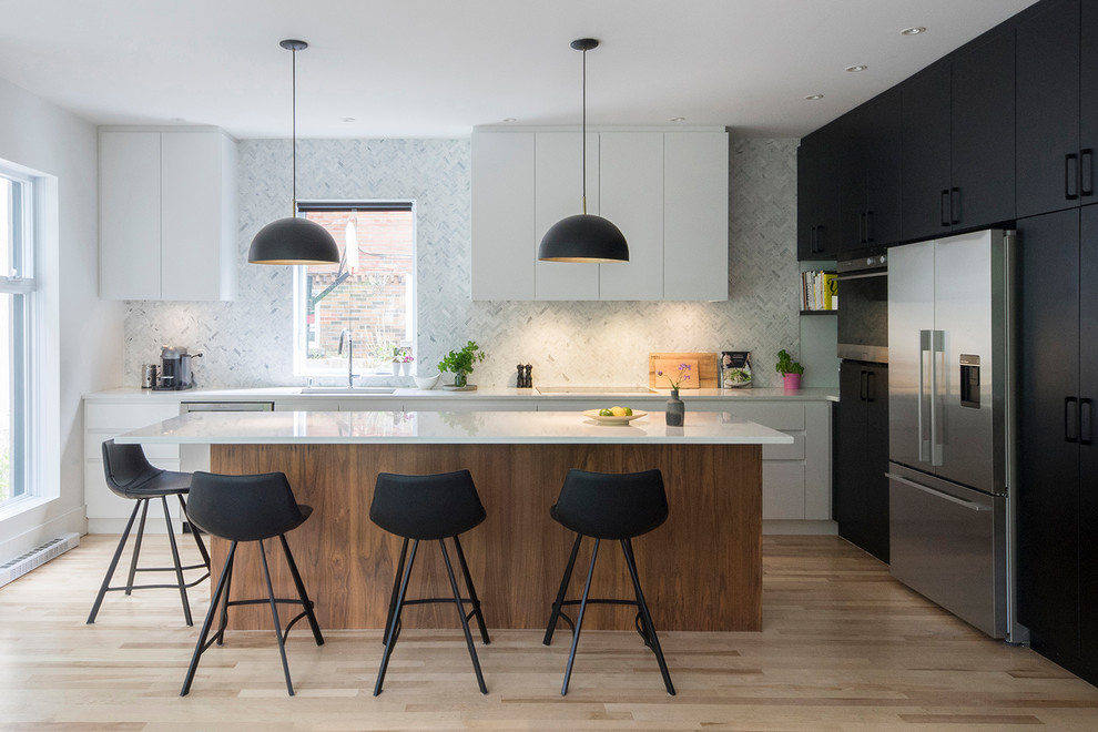 Photo of a contemporary l-shaped kitchen in Montreal with a single-bowl sink, flat-panel cabinets, white splashback, stainless steel appliances, light hardwood floors and with island.