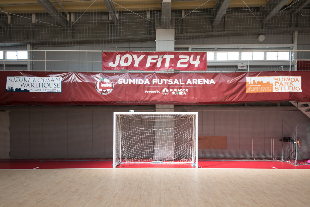 This is an example of an expansive scandinavian indoor sport court in Tokyo with beige walls and exposed beam.