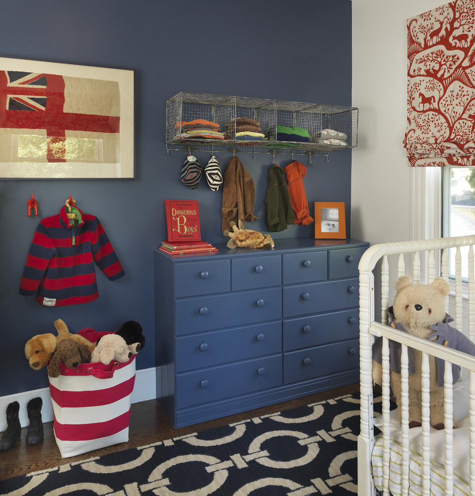 Inspiration for a traditional nursery for boys in Providence with blue walls and dark hardwood floors.