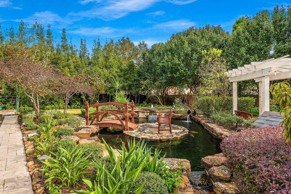 Photo of a mediterranean full sun garden in Houston with with pond.