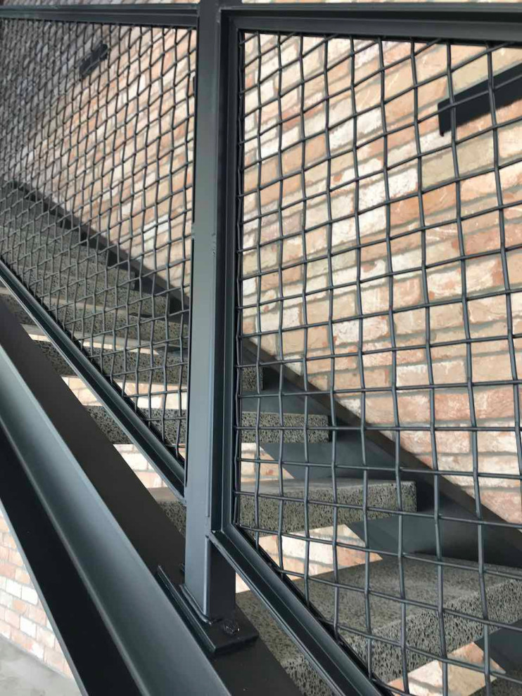 オークランドにあるお手頃価格の中くらいなインダストリアルスタイルのおしゃれな階段 (金属の手すり) の写真