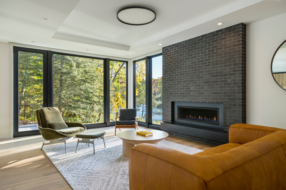 Inspiration for a large scandinavian formal and open concept light wood floor and beige floor living room remodel in Minneapolis with white walls, a standard fireplace, a brick fireplace and no tv