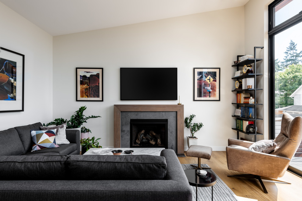 Trendy medium tone wood floor, brown floor and vaulted ceiling living room photo in Seattle with beige walls, a standard fireplace and a wall-mounted tv