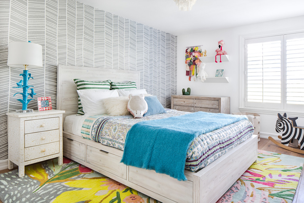 This is an example of a mid-sized transitional kids' bedroom for girls and kids 4-10 years old in Orange County with medium hardwood floors, brown floor and white walls.