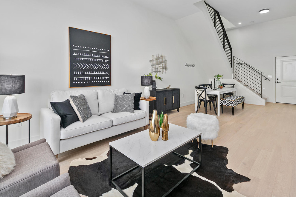 Example of a danish formal and open concept light wood floor living room design in DC Metro with white walls and no fireplace
