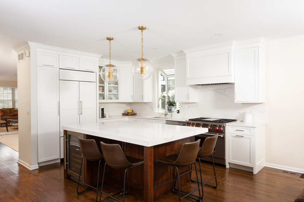 Inspiration for a small transitional l-shaped eat-in kitchen in Chicago with an undermount sink, shaker cabinets, white cabinets, quartz benchtops, white splashback, stone slab splashback, white appliances, dark hardwood floors, with island, brown floor and white benchtop.