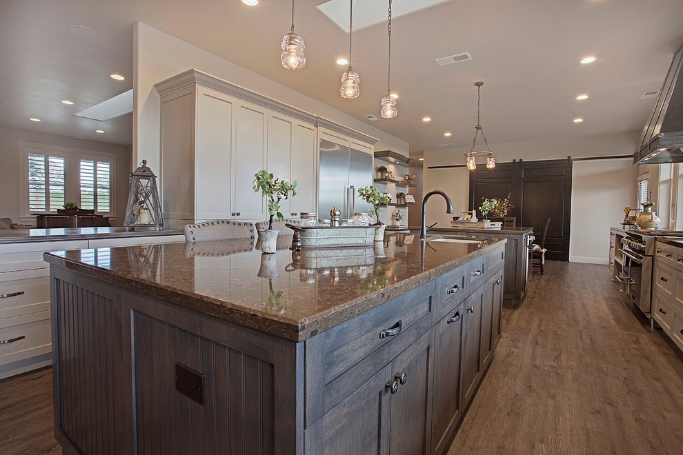 Design ideas for a large transitional open plan kitchen in Sacramento with a farmhouse sink, shaker cabinets, grey cabinets, granite benchtops, multi-coloured splashback, stainless steel appliances, vinyl floors and multiple islands.