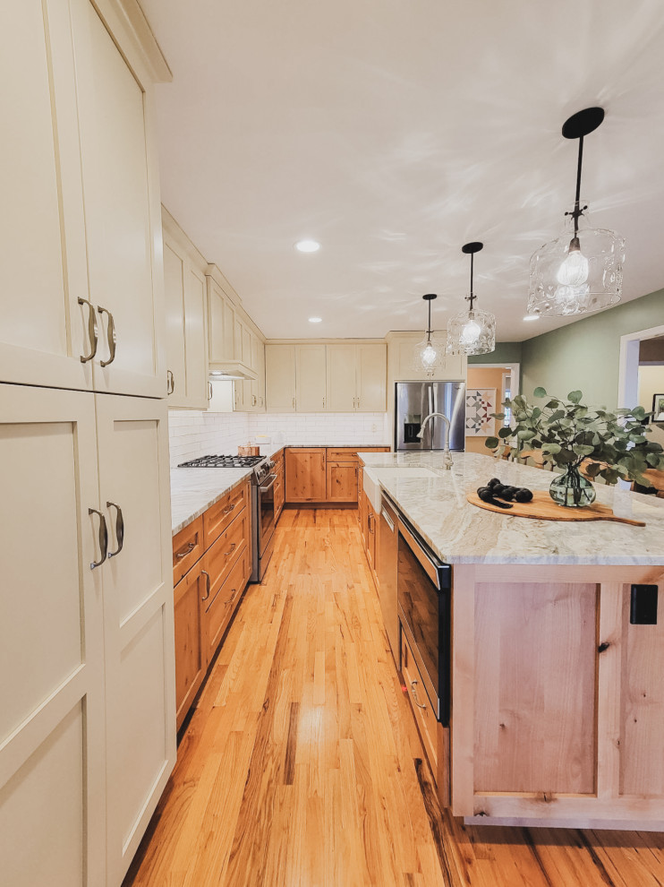 Exempel på ett mellanstort klassiskt grön grönt l-kök, med en rustik diskho, skåp i shakerstil, skåp i mellenmörkt trä, marmorbänkskiva, vitt stänkskydd, stänkskydd i tunnelbanekakel, rostfria vitvaror, mellanmörkt trägolv, en köksö och brunt golv