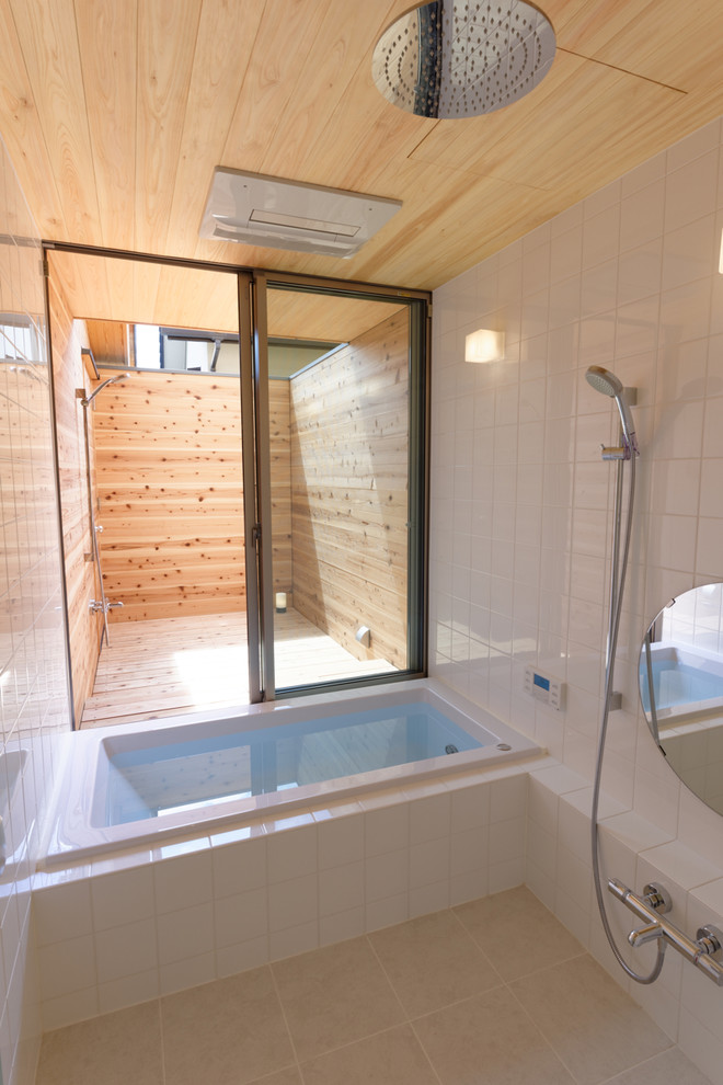 Modern bathroom in Kyoto with a drop-in tub, a double shower, white tile, porcelain tile, white walls and beige floor.