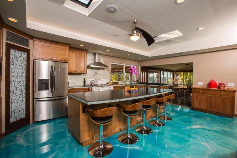Tropical kitchen in Salt Lake City with concrete benchtops, stainless steel appliances and with island.