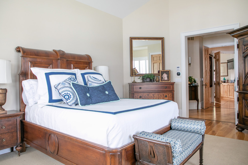 Large beach style master bedroom in Milwaukee with beige walls, medium hardwood floors, no fireplace and brown floor.
