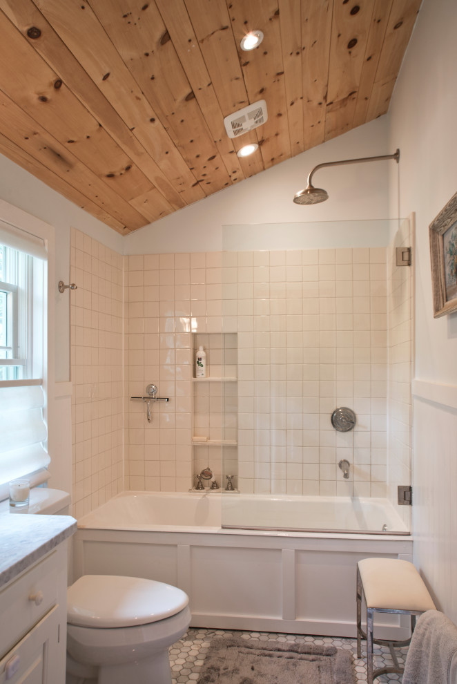 Design ideas for a mid-sized traditional 3/4 bathroom in New York with open cabinets, white cabinets, a drop-in tub, an alcove shower, a two-piece toilet, white tile, ceramic tile, grey walls, marble floors, an undermount sink, marble benchtops, grey floor, a hinged shower door, grey benchtops, a single vanity, a freestanding vanity, wood and wood walls.