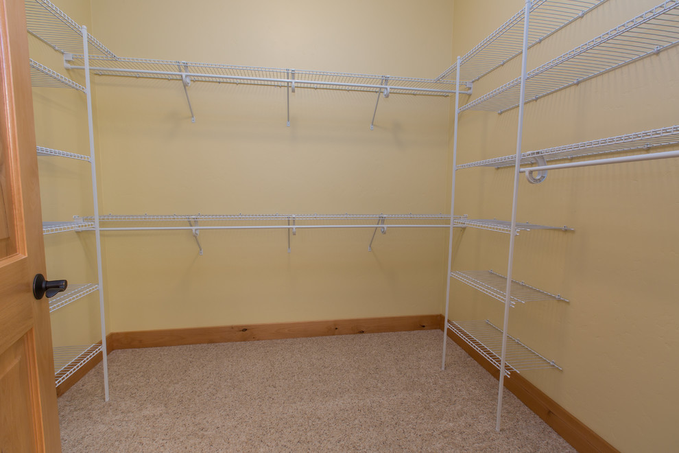 Photo of a mid-sized arts and crafts gender-neutral walk-in wardrobe in Other with carpet.