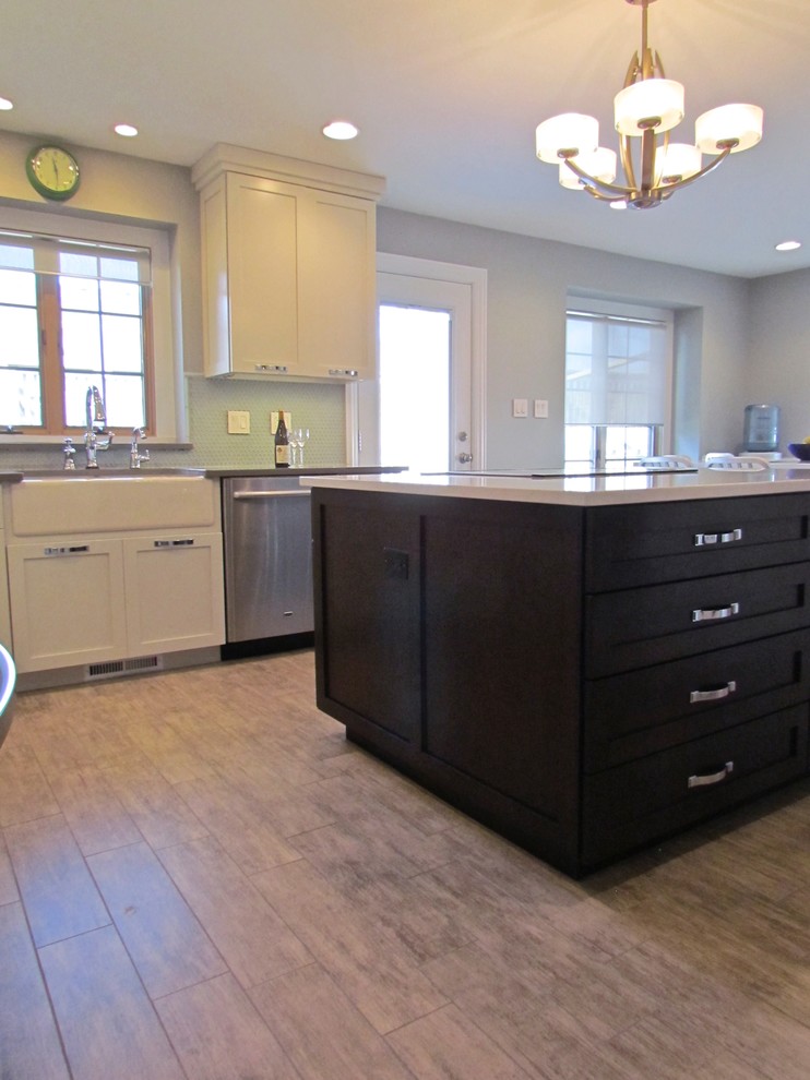 Inspiration for a transitional l-shaped porcelain tile eat-in kitchen remodel in Chicago with a farmhouse sink, shaker cabinets, white cabinets, quartz countertops, blue backsplash, glass tile backsplash, stainless steel appliances and an island