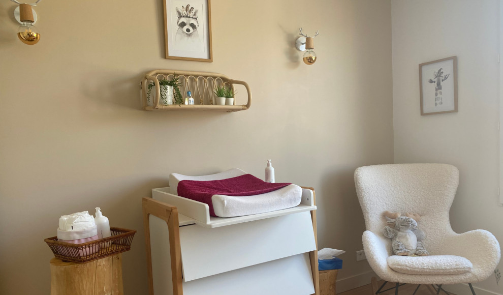 Cette image montre une chambre de bébé neutre nordique de taille moyenne avec un mur beige, parquet clair et un sol beige.