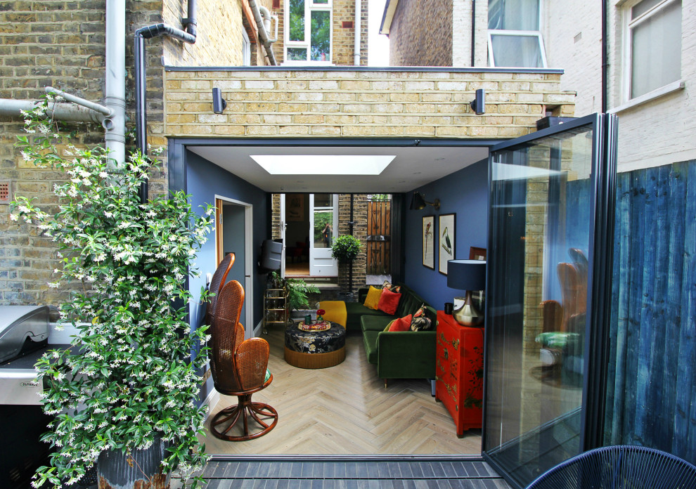 Kleines, Abgetrenntes Rustikales Wohnzimmer mit Hausbar, blauer Wandfarbe, hellem Holzboden und TV-Wand in London