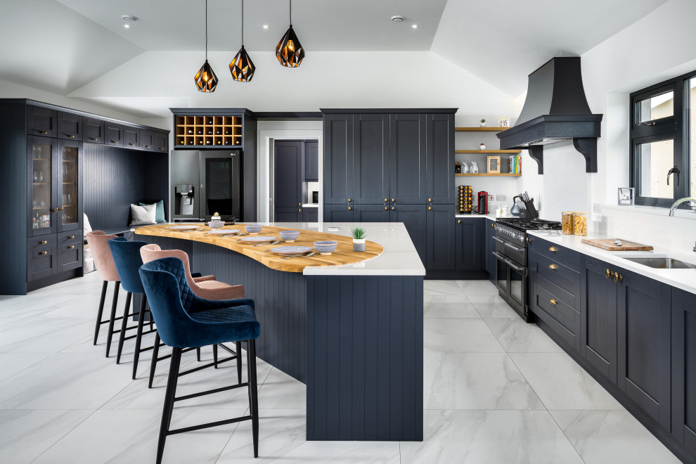 Example of a huge classic l-shaped gray floor open concept kitchen design in Other with an undermount sink, shaker cabinets, blue cabinets, quartzite countertops, white backsplash, black appliances, an island and white countertops