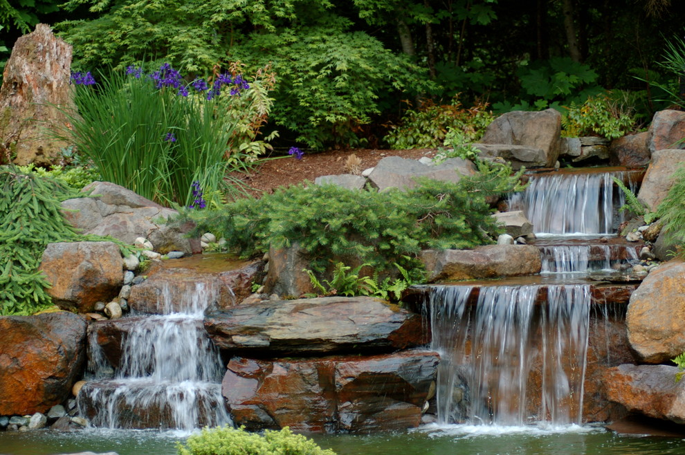 Large country backyard partial sun garden in Seattle with a water feature for spring.